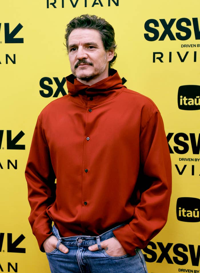 Pedro Pascal wearing a stylish high-collar red shirt and jeans at SXSW event with event signage in the background