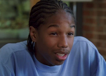 Wallace from "The Wire" wearing a casual shirt, in a close-up scene inside a room