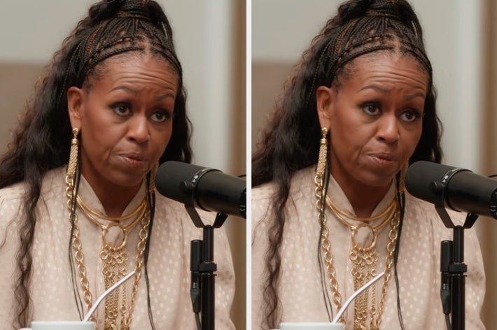 Person wearing long earrings and layered gold necklaces, speaking into a microphone