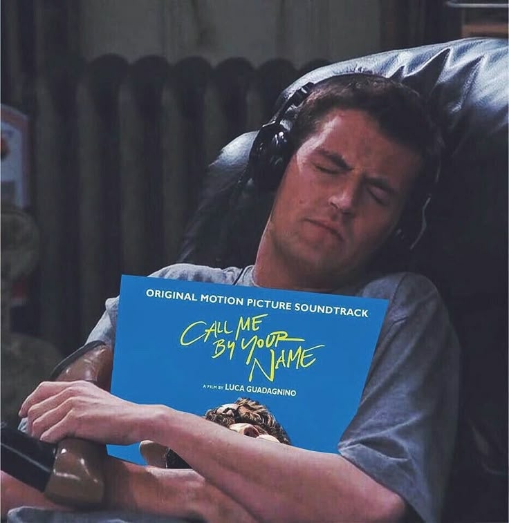 Persona escuchando la banda sonora de "Call Me by Your Name" con cascos, recostado en un sofá