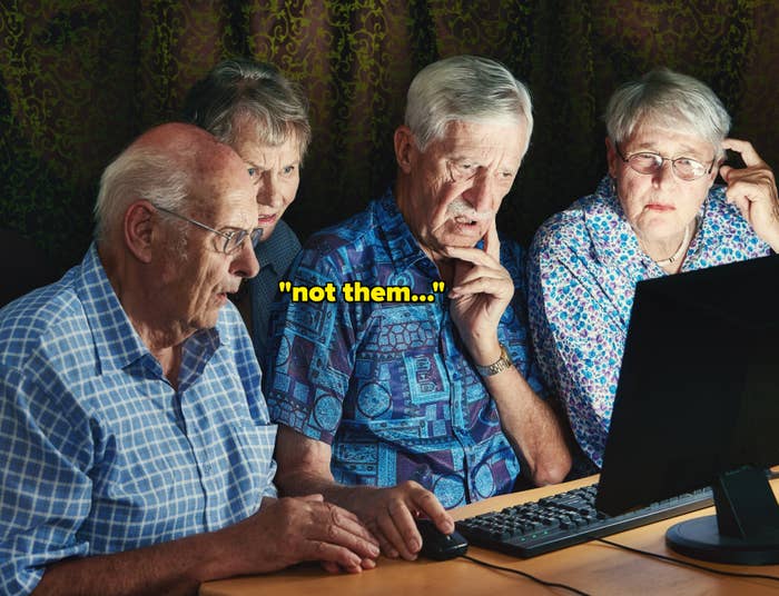 Four elderly people intently focus on a computer screen, appearing curious and engaged