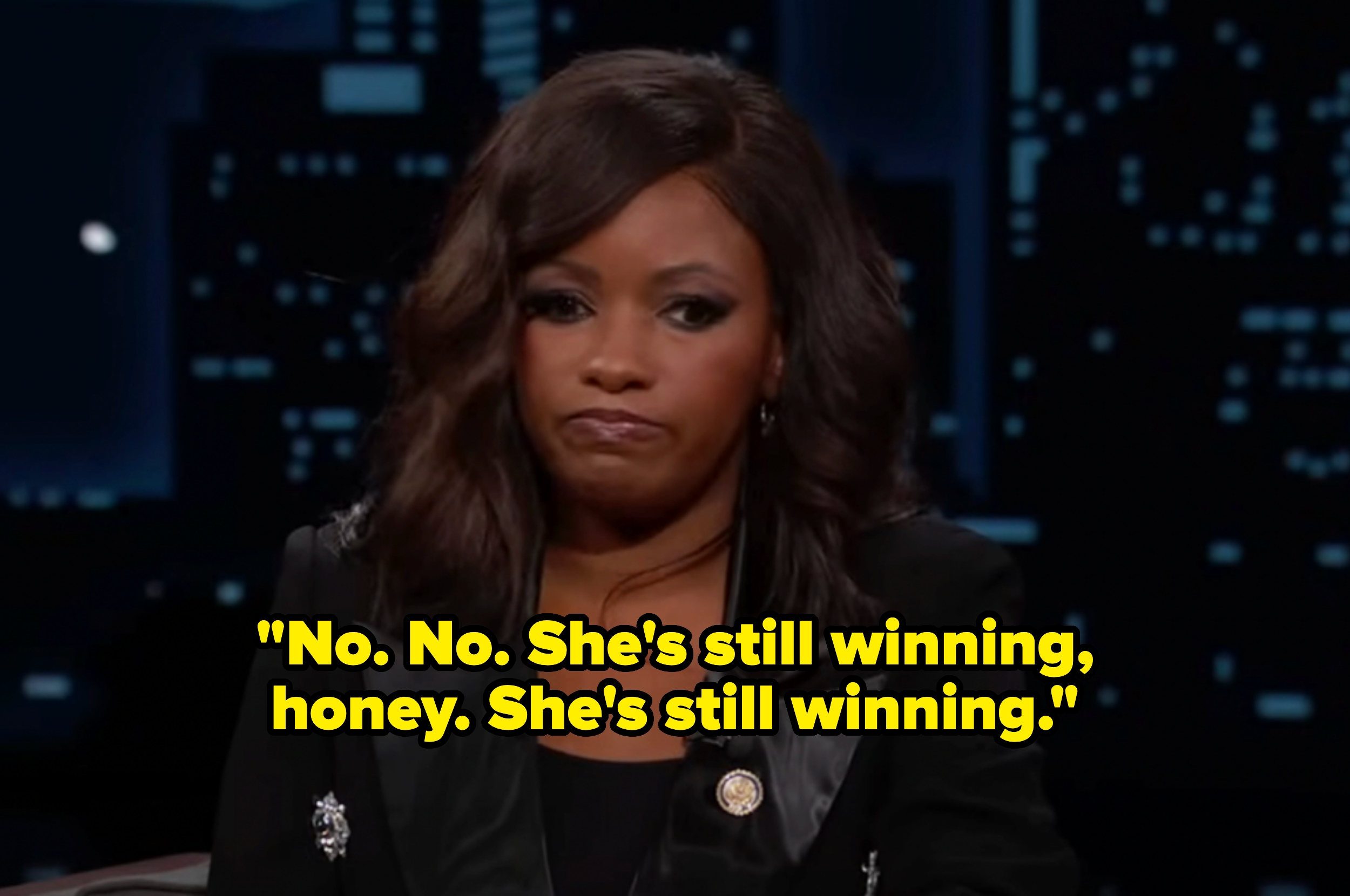 Woman in a suit on a talk show set with text overlay: &quot;No. No. She&#x27;s still winning, honey. She&#x27;s still winning.&quot;