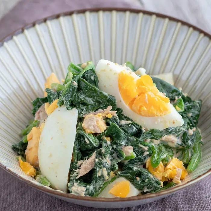 ほうれん草とゆで卵、ツナのサラダが盛られたボウル。クリーミーなドレッシングがかかっている。