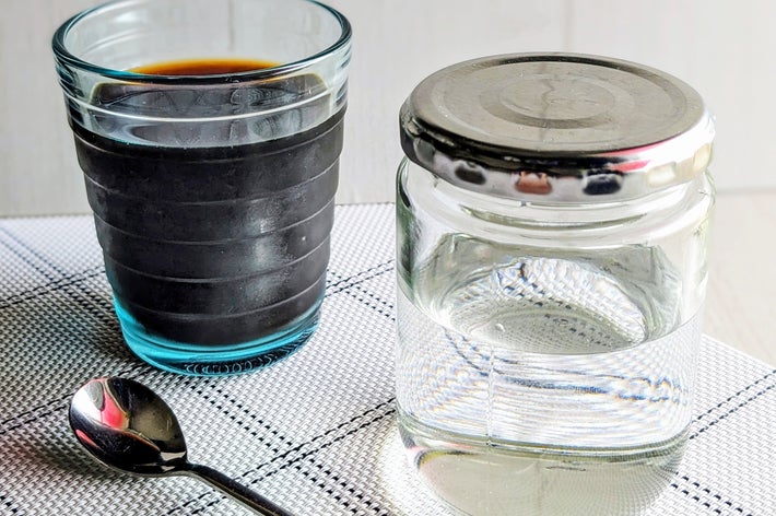 テーブルにアイスコーヒーとふた付きの水の入った瓶、スプーンが置かれている。
