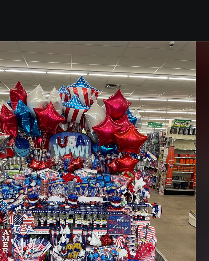 A store display with July 4th themed items, including balloons and decorations, arranged for a festive holiday presentation