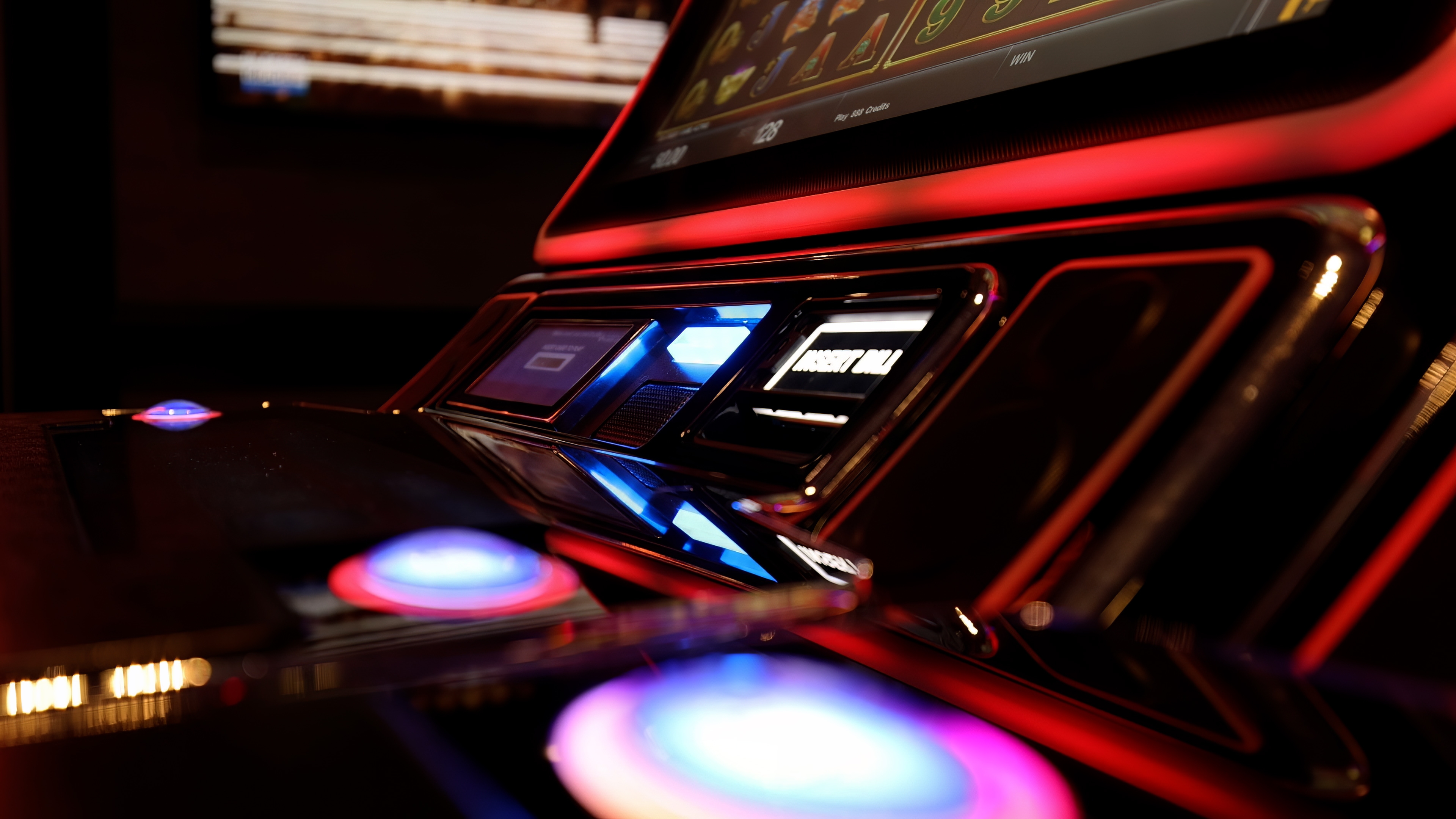 Close-up of a modern slot machine interface with illuminated buttons and a digital screen displaying graphics