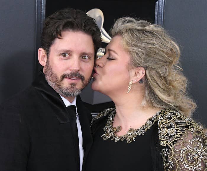 Kelly Clarkson kissing Brandon Blackstock on the cheek at a formal event