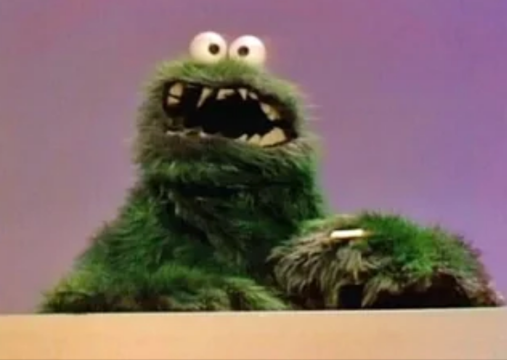 Furry Cookie Monster puppet with jagged teeth