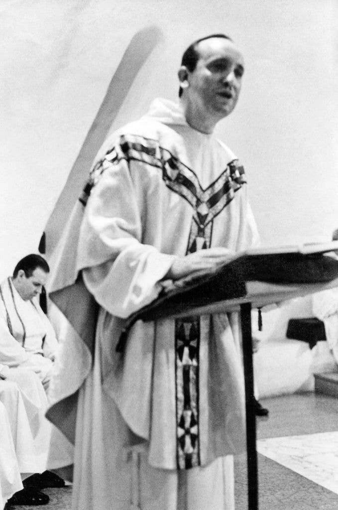 Jorge Bergoglio, in a traditional religious robe, speaks at a podium during a church service