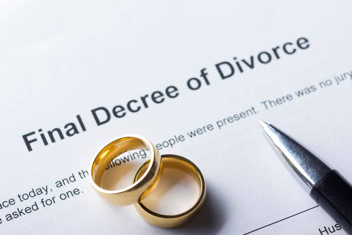 Two gold rings beside a document titled "Final Decree of Divorce" with a pen nearby