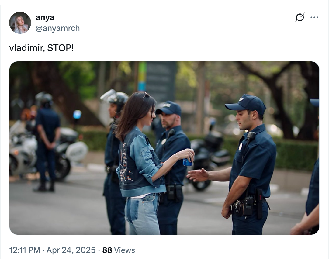 A person hands an envelope to a police officer on a street, with police bikes in the background