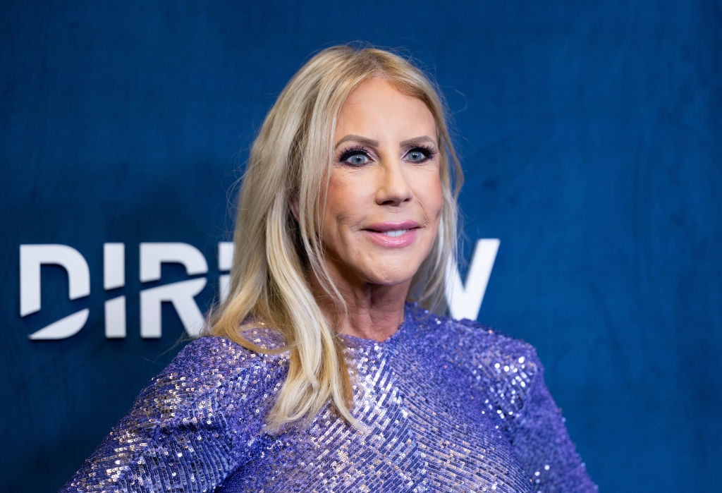 A person in a sparkly, sequined outfit poses at an event