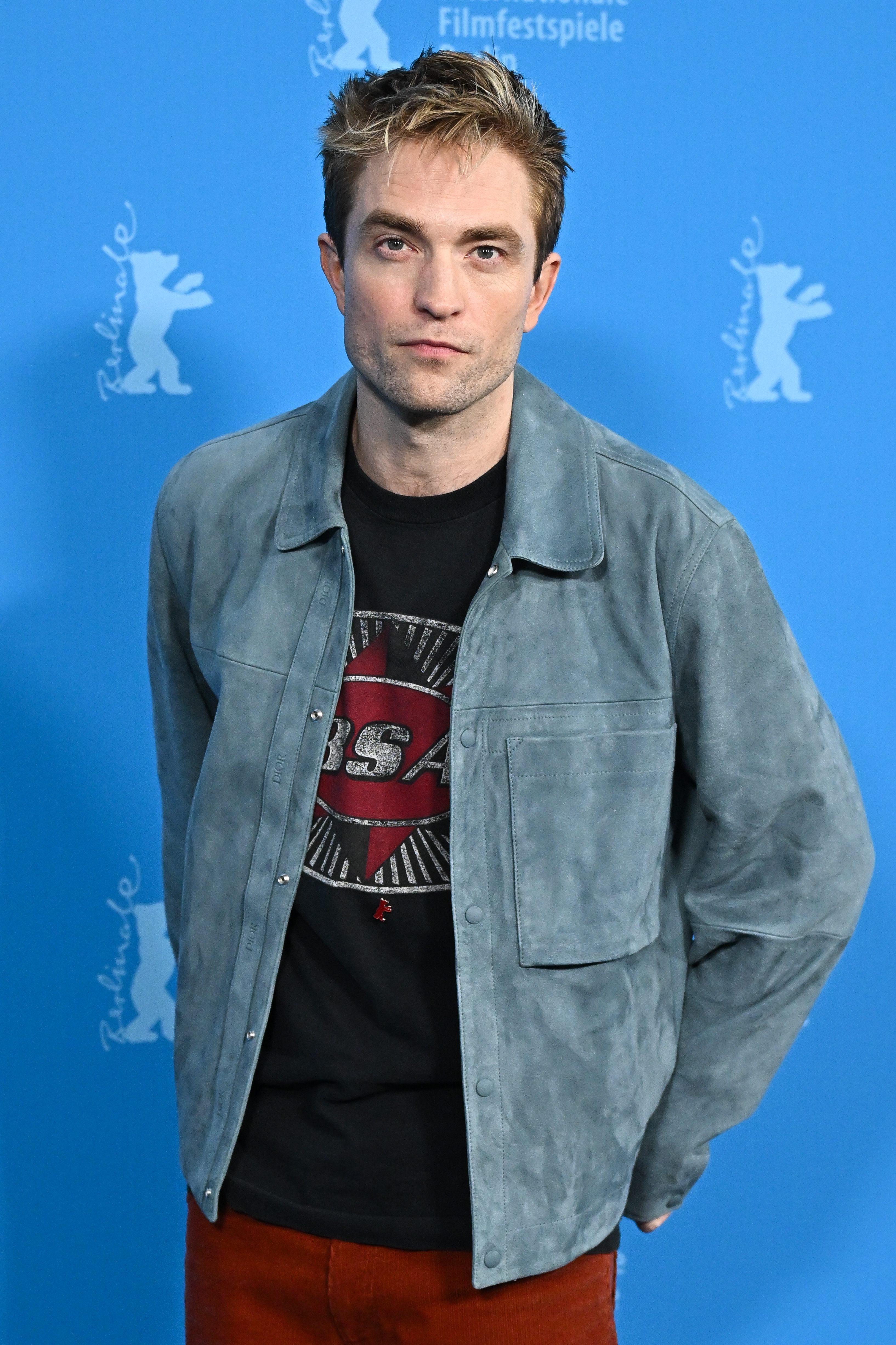 Person in a casual jacket over a graphic tee poses at a film festival backdrop