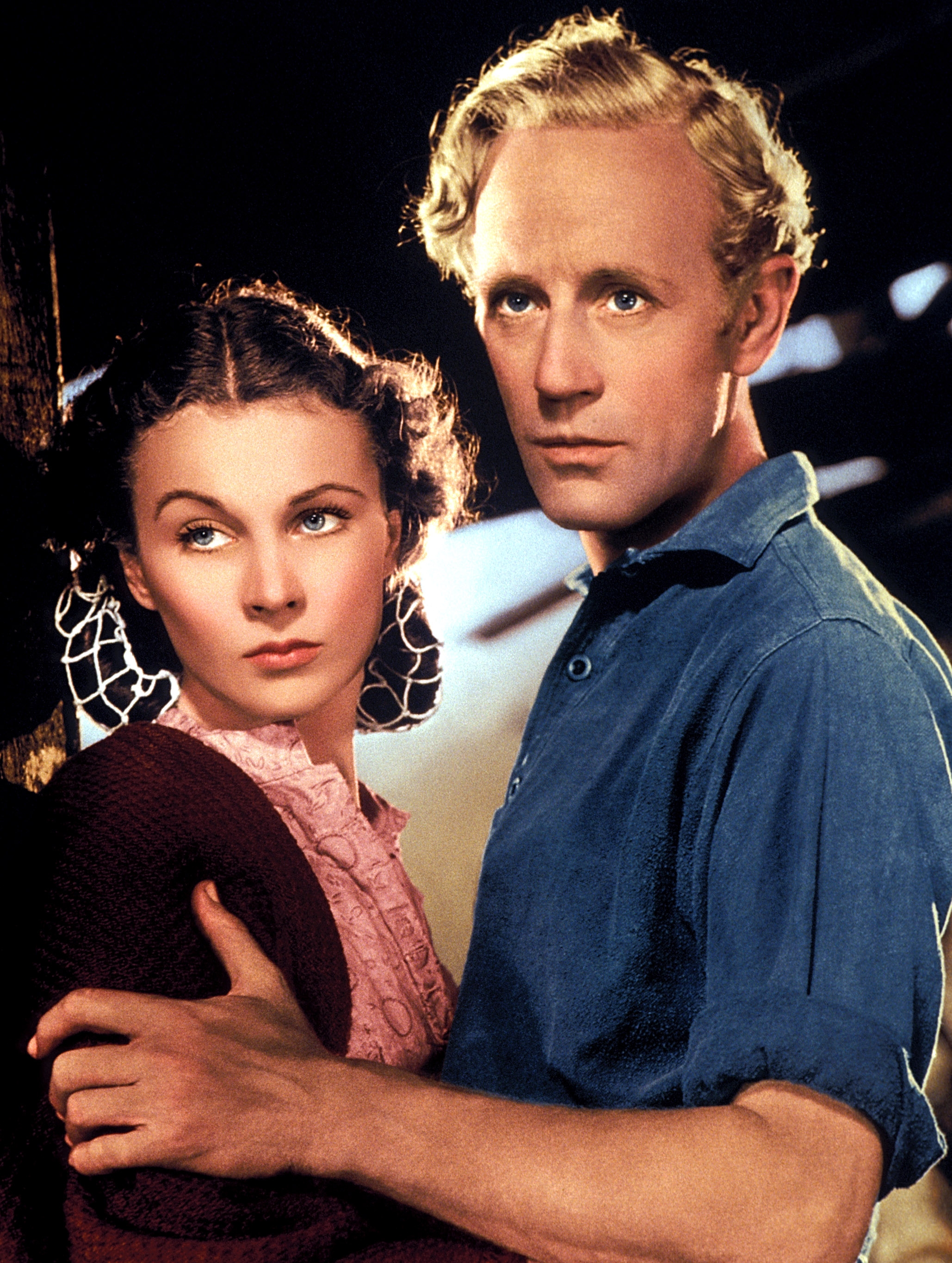 Classic movie scene with a woman in a vintage dress and a man in a blue shirt, both gazing intently
