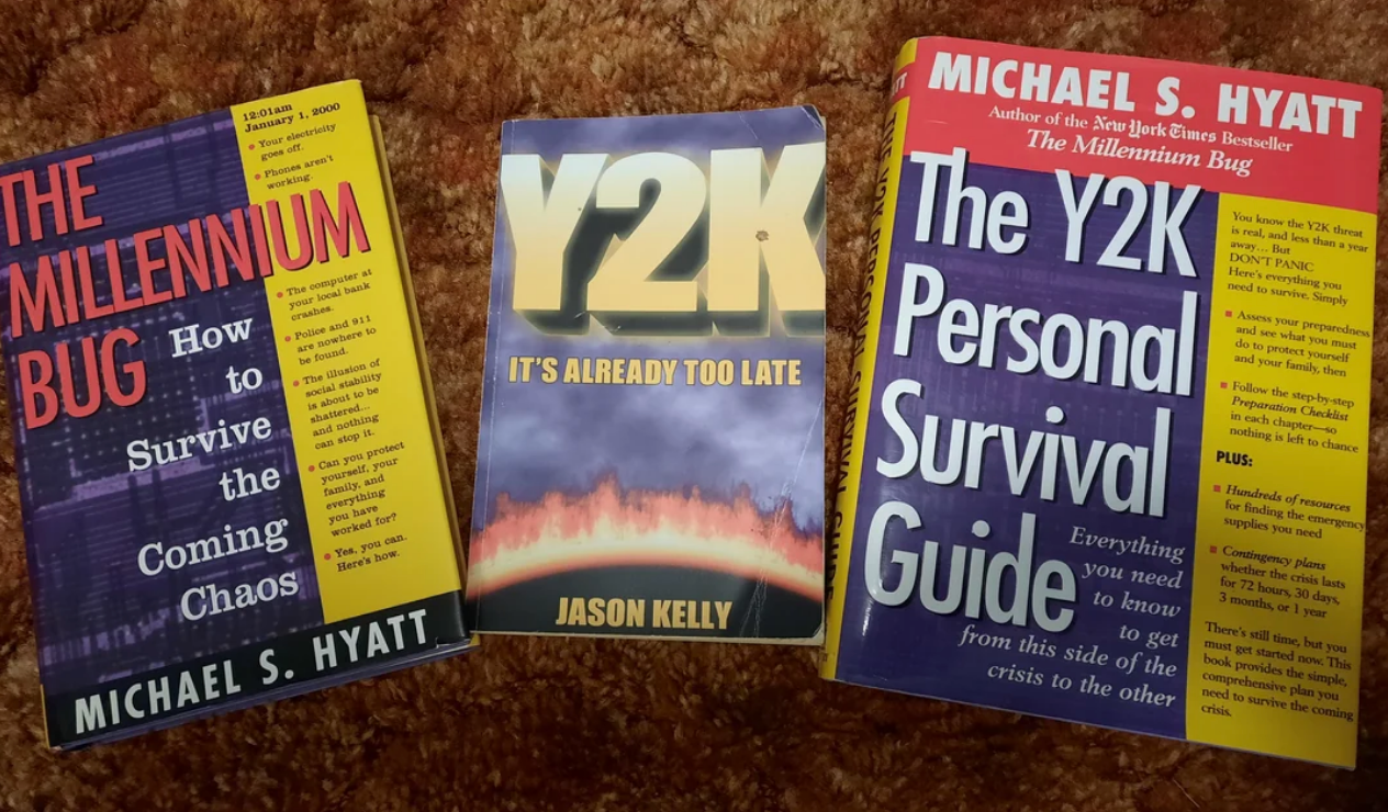 Three Y2K-themed books are displayed: "The Millennium Bug" by Michael S. Hyatt, "Y2K: It's Already Too Late" by Jason Kelly, and "The Y2K Personal Survival Guide" by Michael S. Hyatt