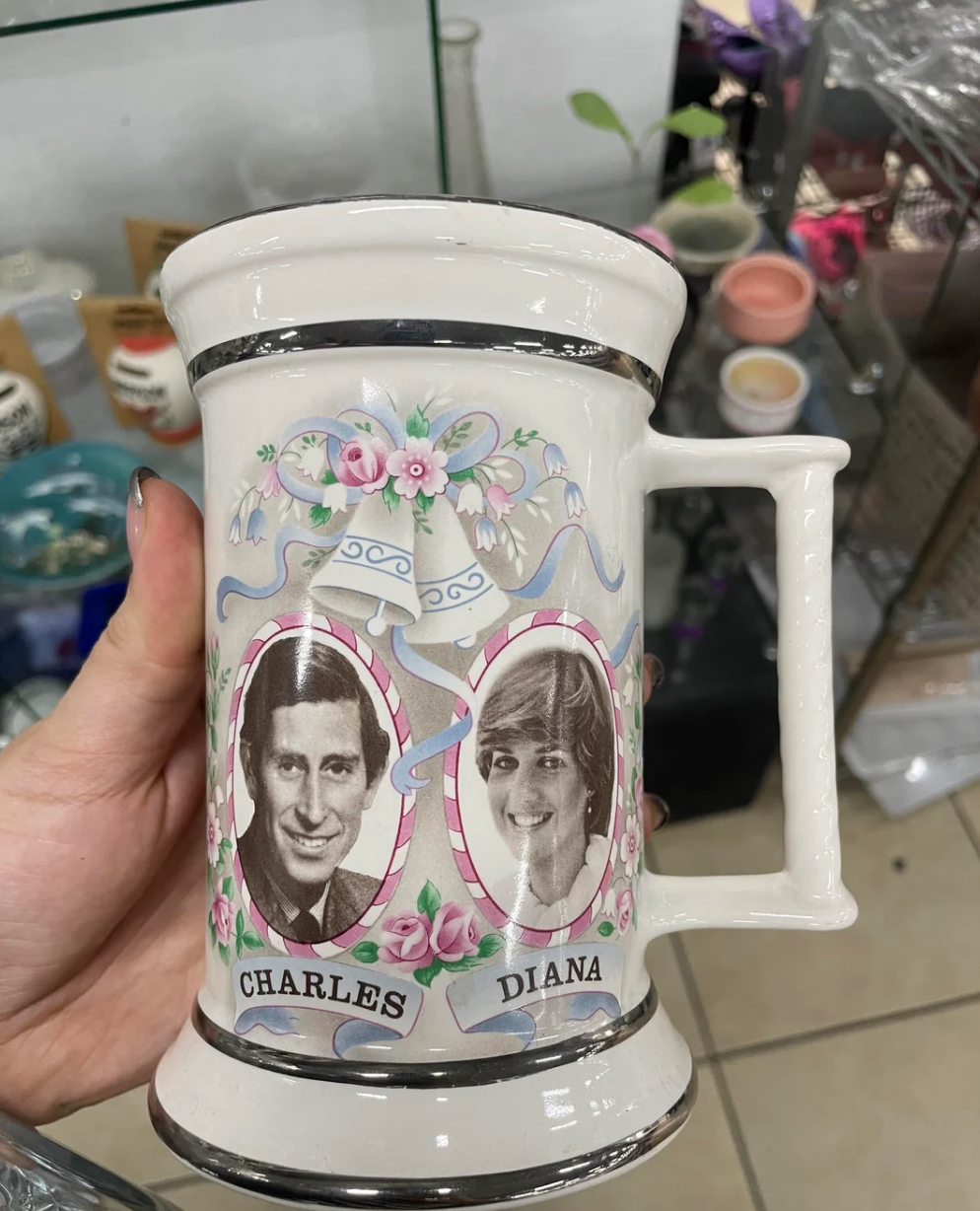 Ceramic mug with portraits labeled "Charles" and "Diana," adorned with floral and ribbon decorations