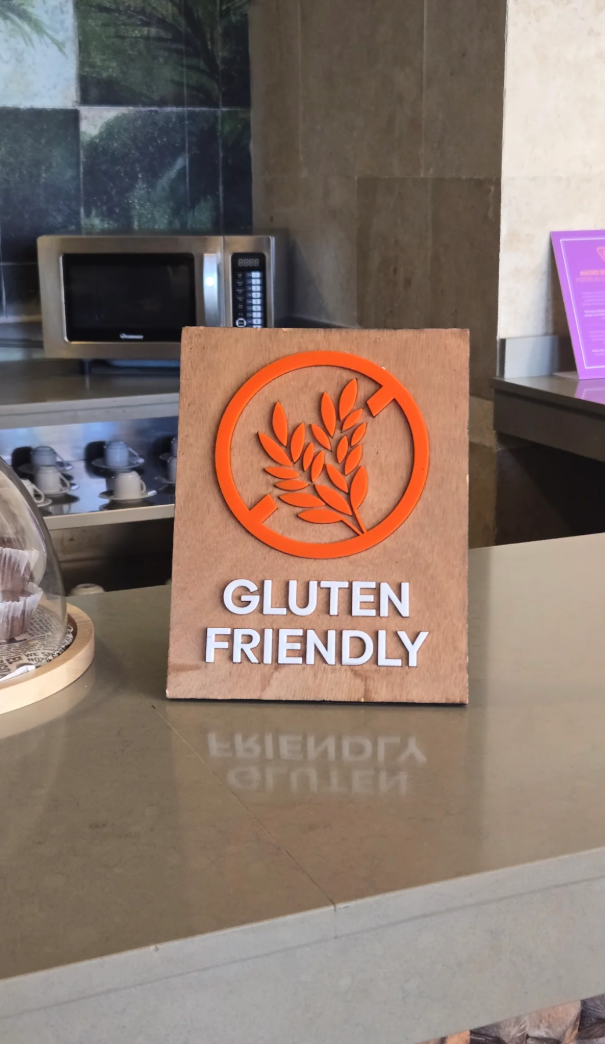 Sign on a counter reads "Gluten Friendly" with a wheat symbol crossed out, indicating gluten-free options available