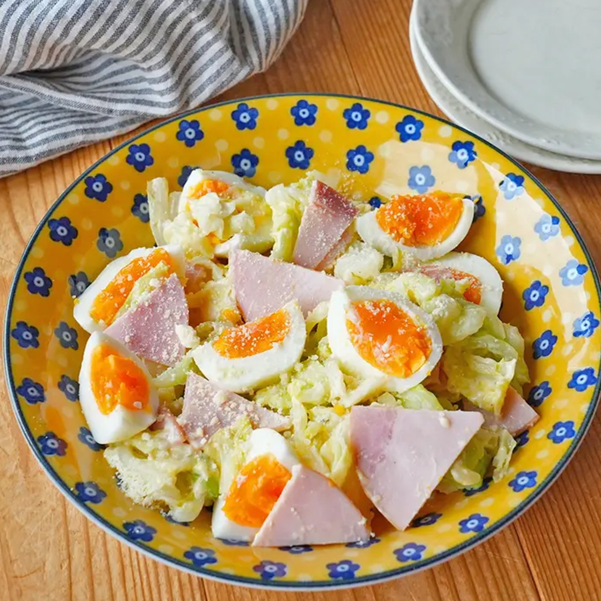 皿に盛られたハムとゆで卵のサラダがテーブル上に置かれている。