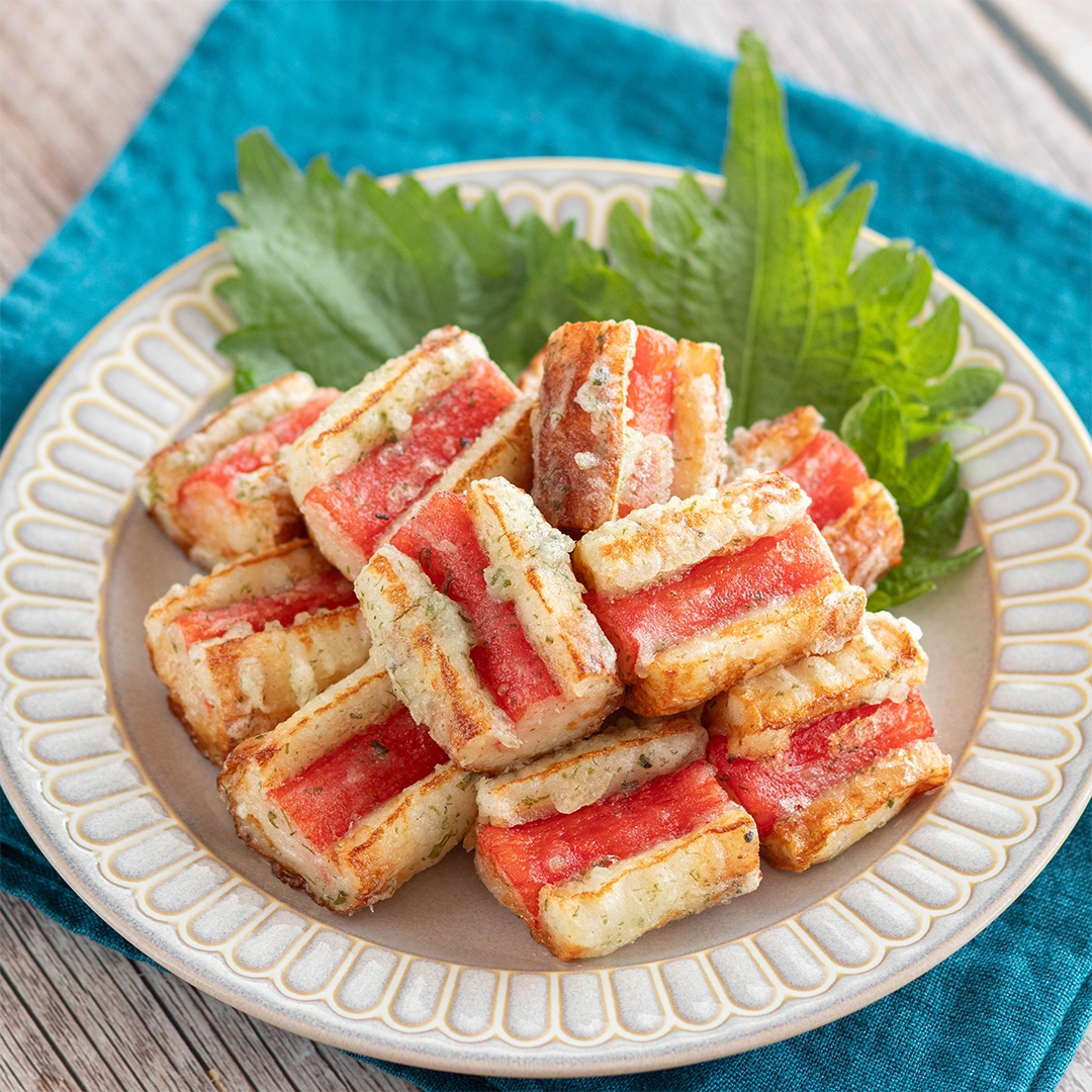 お皿に盛られた天ぷら風の食べ物。外側はカリッと揚げられており、葉っぱが飾られている。