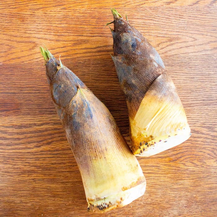 木製の表面に2つのタケノコが置かれている。