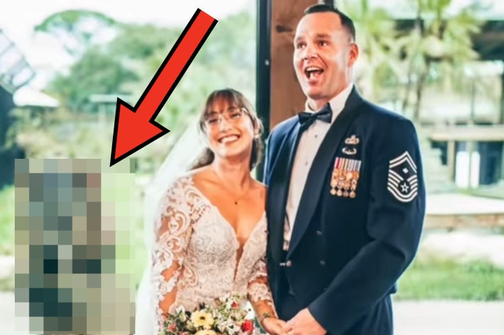 新郎新婦が笑顔で動物園のガラス前に立ち、ライオンが背景にいる結婚式の写真。新婦はレースのドレス。