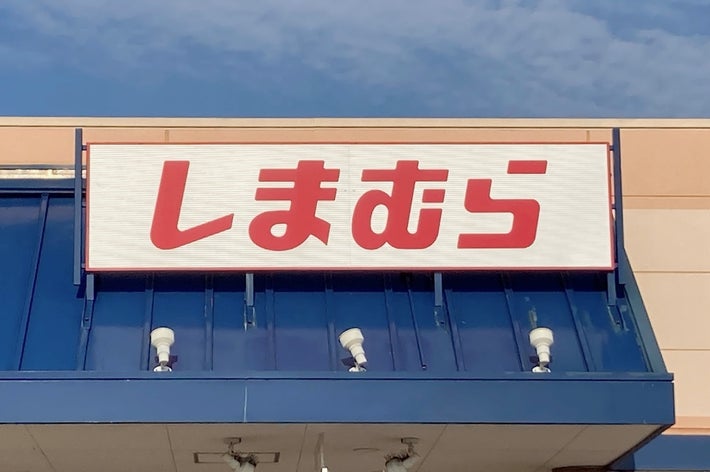 Storefront with large sign displaying &ldquo;しまむら&rdquo; in bold Japanese characters above a blue entrance