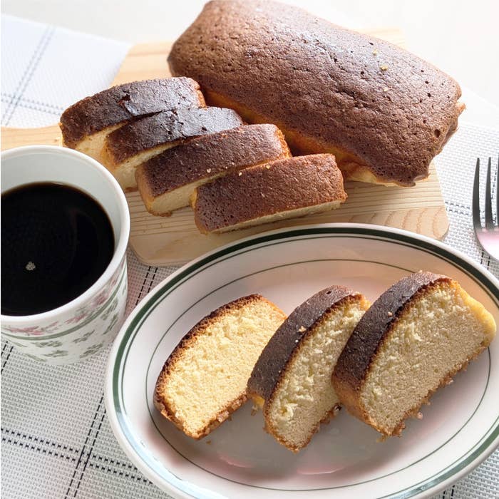 カットされたパウンドケーキとコーヒーカップがテーブルに並んでいる。