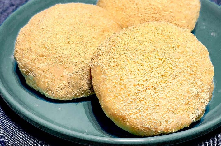 皿に乗った三つのきな粉もち。樹脂製の深い色合いの皿に盛り付けられている。