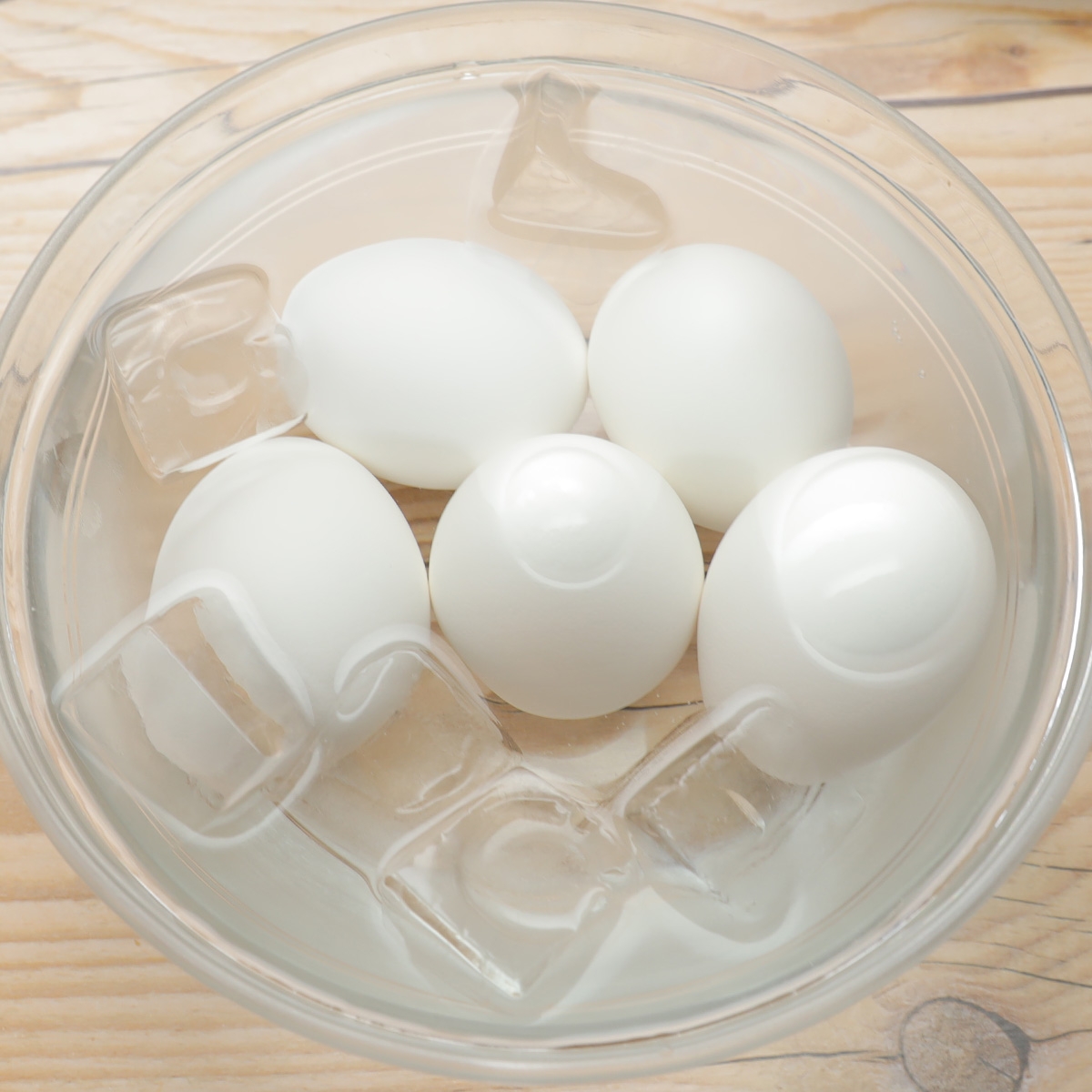 氷水が入ったボウルに白いゆで卵が5個入っています。