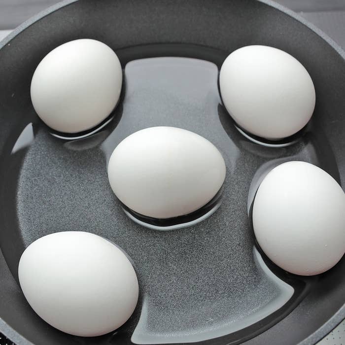 鍋の中に水と入った5つの卵。