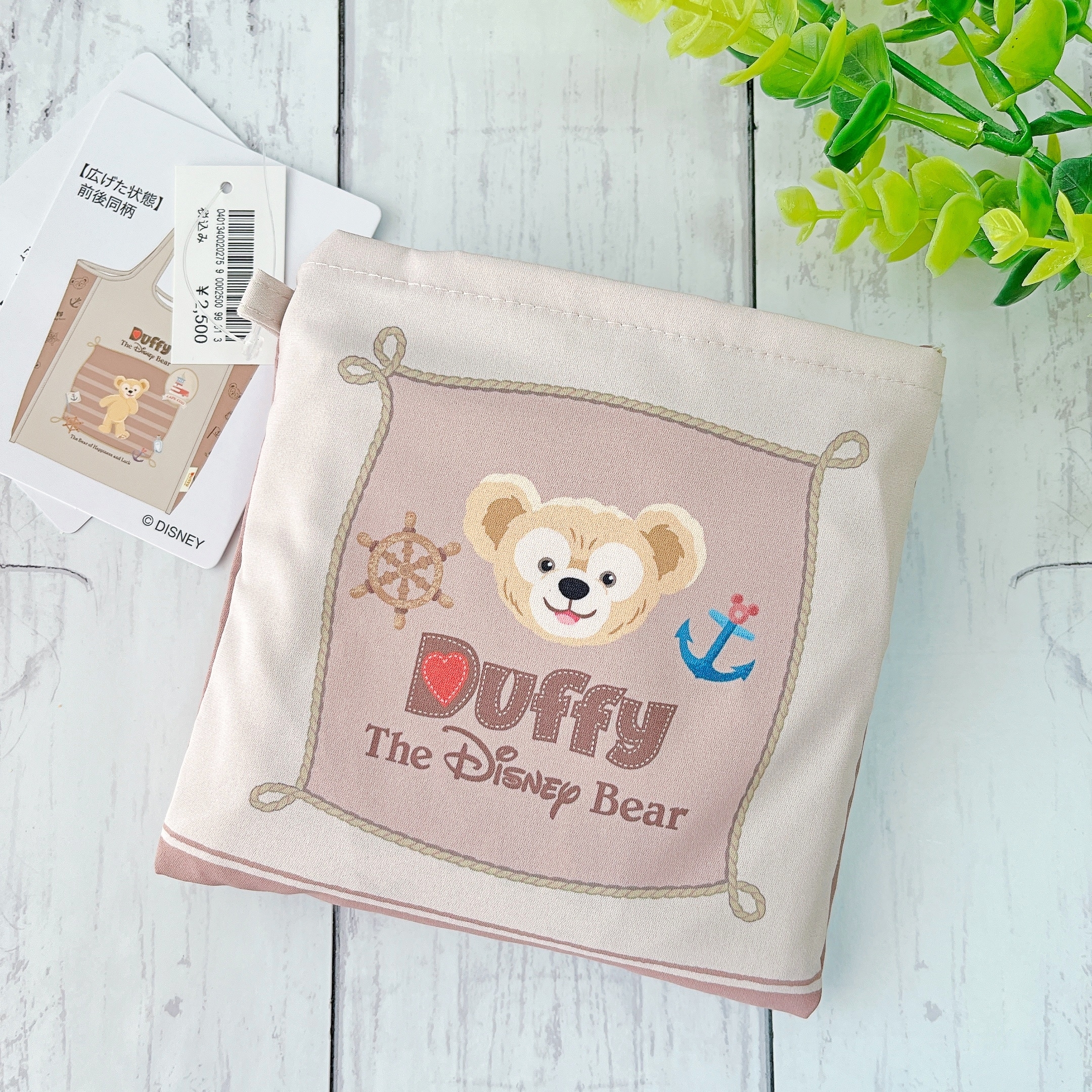 ディズニーベア、ダッフィーの顔が描かれた布地。タグには商品情報が印刷されている。