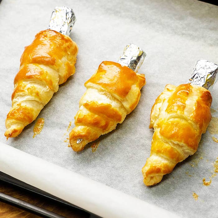 ベーキングシートに並んだ3つの焼きたてのクロワッサン型のペイストリー。