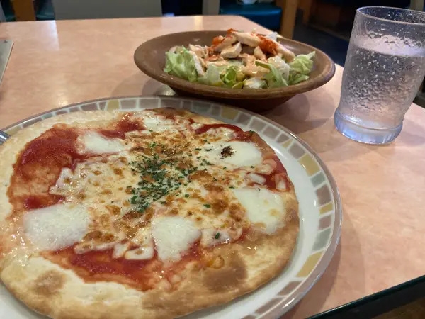 サイゼリヤで注文したピザとサラダ、無料の炭酸水(都内で撮影/BuzzFeed Japan)