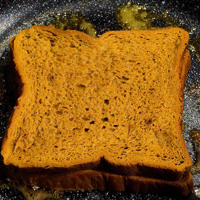 トーストされたパンのスライスが、焼くために準備されたフライパンに置かれています。