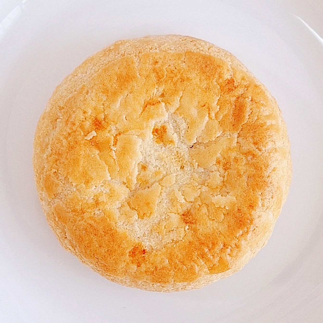 白い皿にのった焼き菓子。表面にひび割れがある。