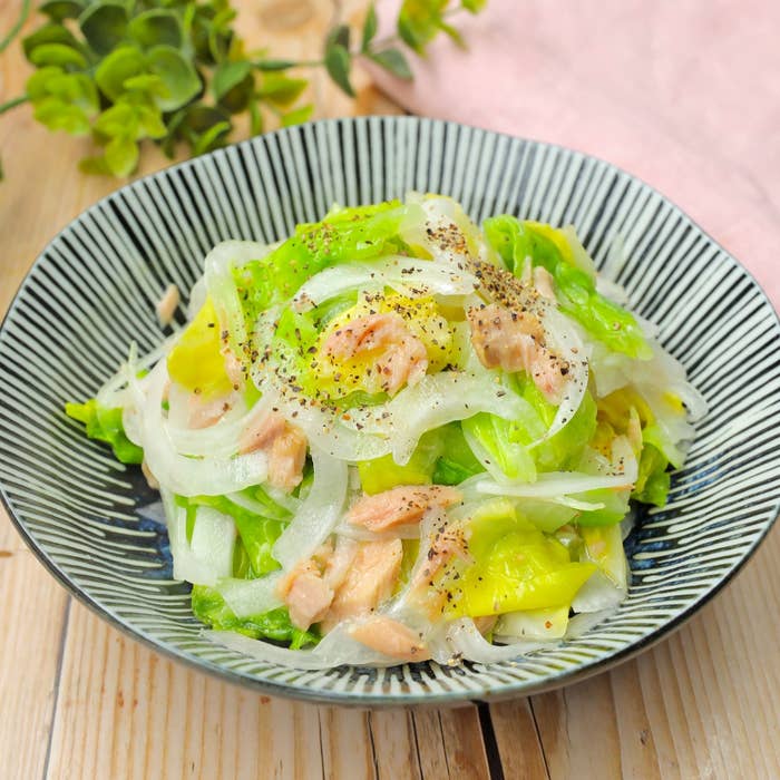 レタス、玉ねぎ、ツナで作られたサラダが皿に盛られている。上に黒胡椒が振りかけられている。