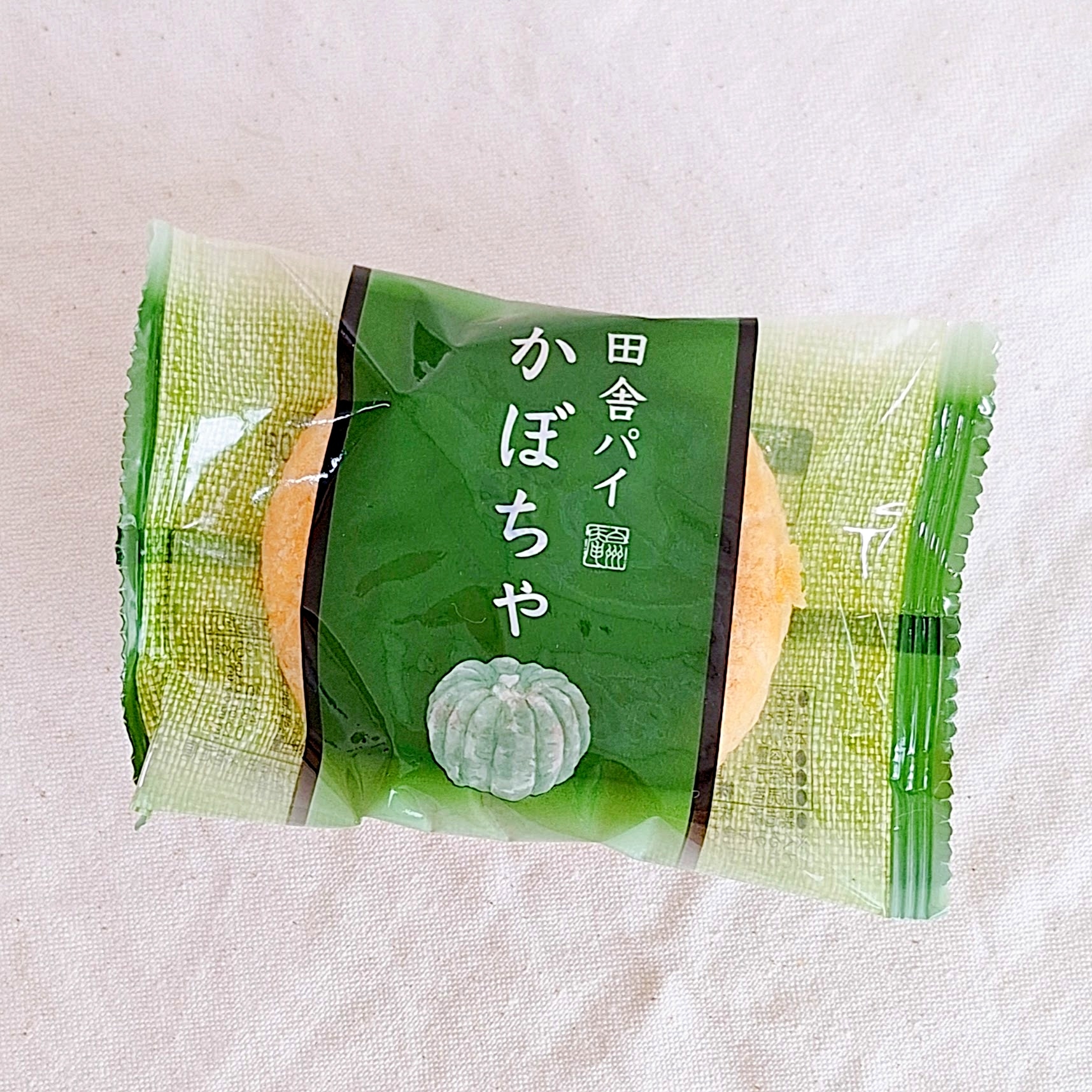 パッケージに包まれたかぼちゃ味の田舎パイがテーブルに置かれている。