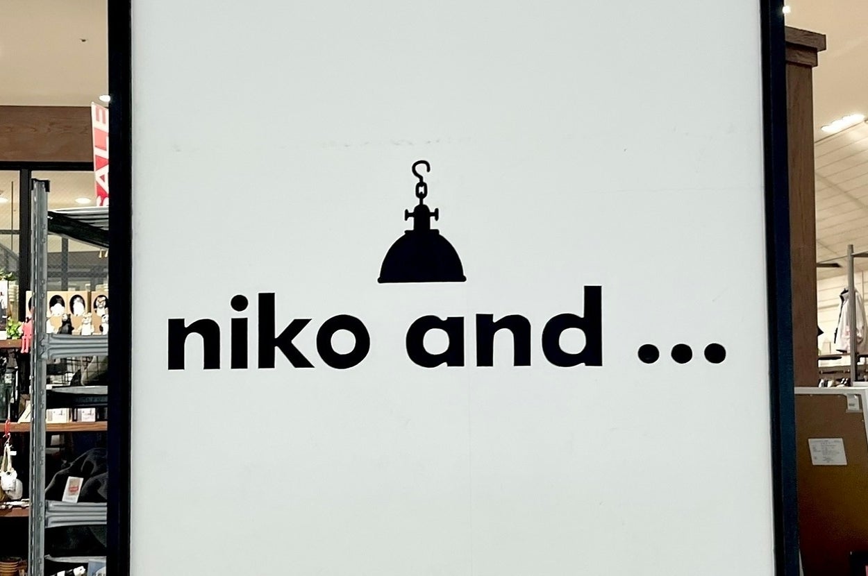 「niko and ...」のロゴ看板。デザインにはランプのシルエットが含まれています。