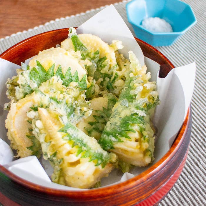 竹の子とシソの天ぷらが器に盛られている。近くに塩が添えられている。