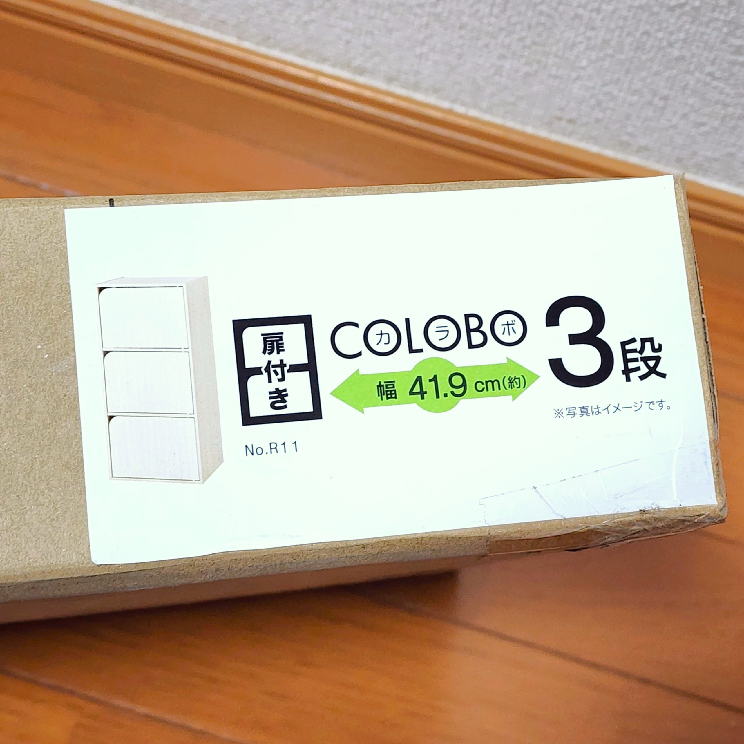 段ボール箱のラベルに「扉付きCOLOB 3段、幅41.9cm」と書かれている。