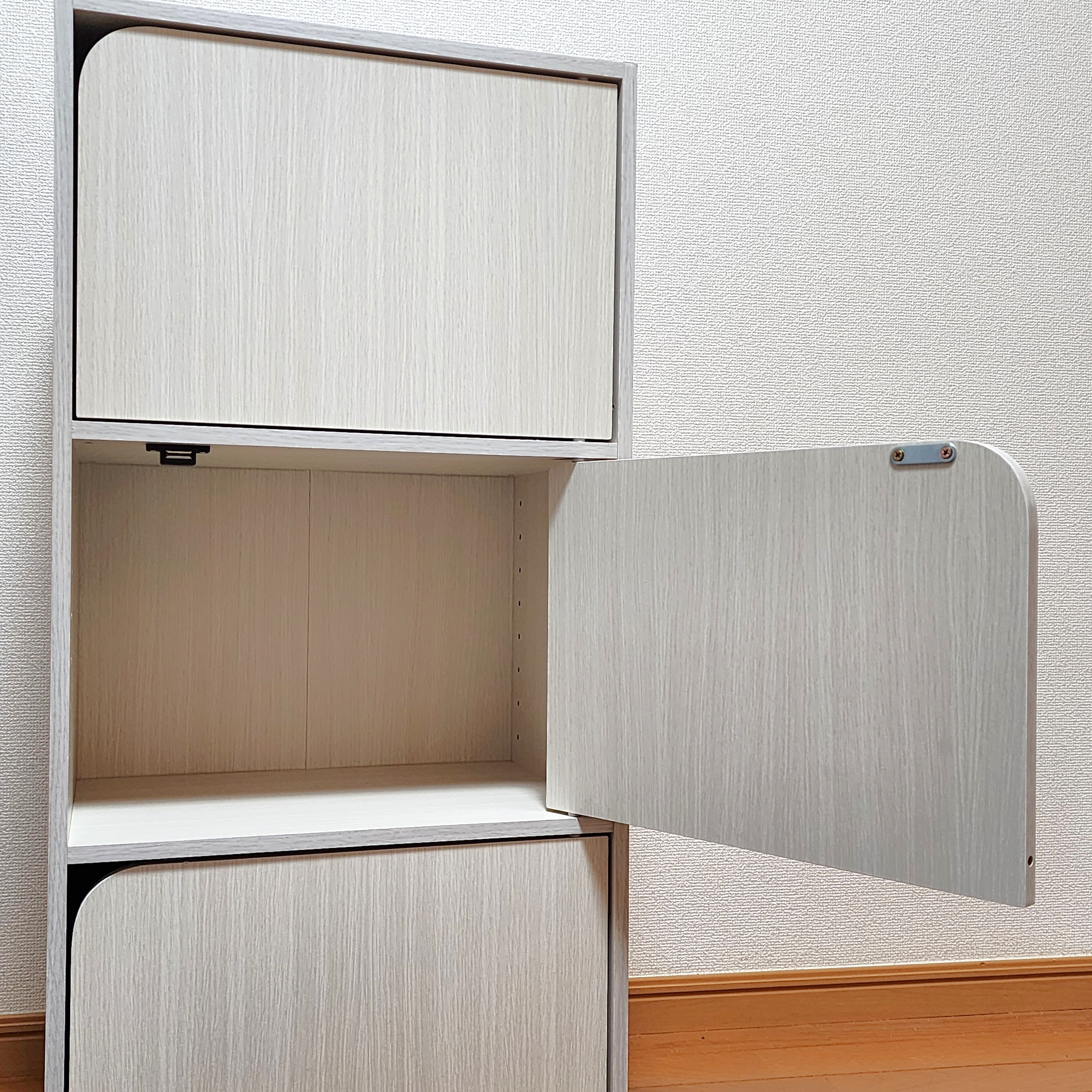 開いたドアのある白い収納キャビネット。上部にはドアが閉じたコンパートメントが2つあります。