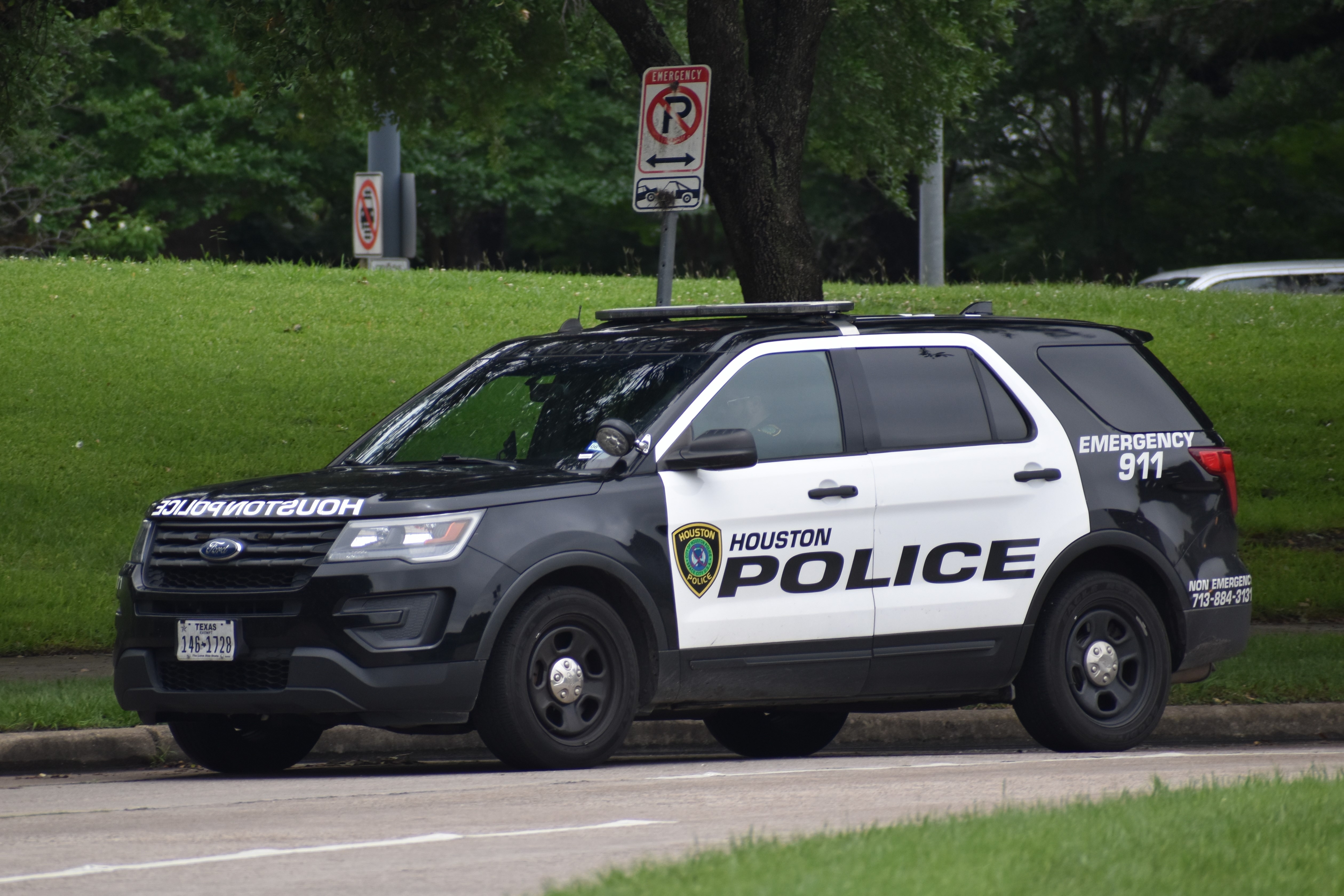Houston police SUV parked on the street, showing emergency number 911 and city emblem on the vehicle side