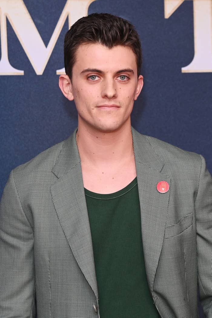 Individual on the red carpet wearing a checked blazer over a green top