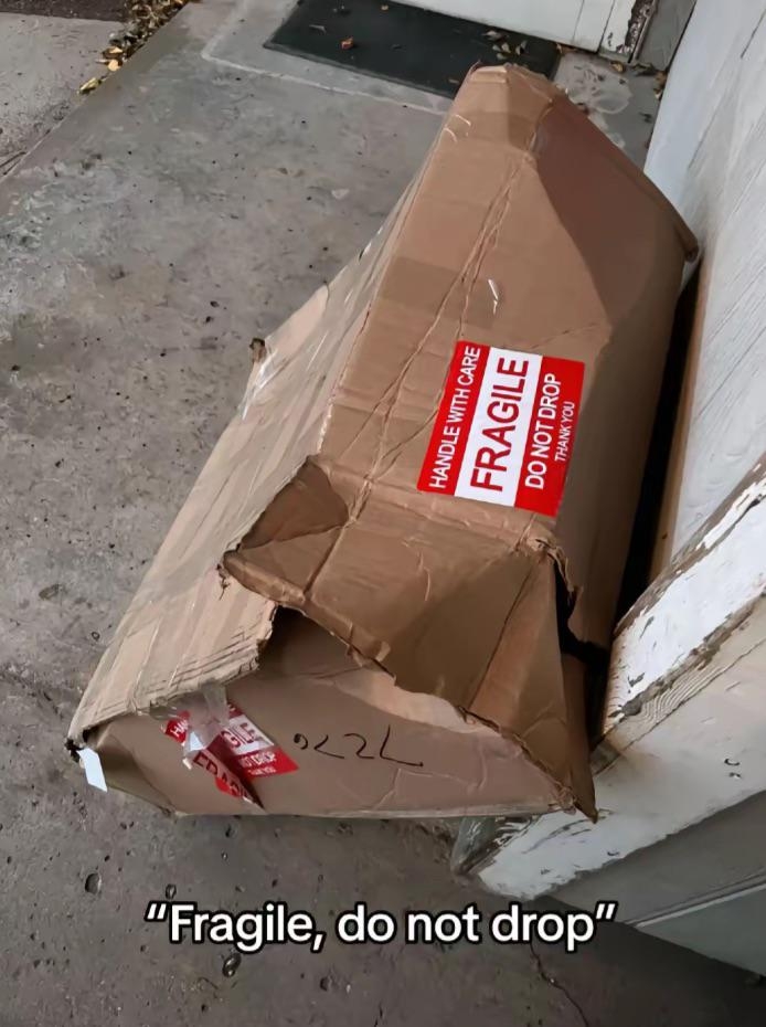 Damaged cardboard box labeled "Fragile, do not drop" with visible dents and tears