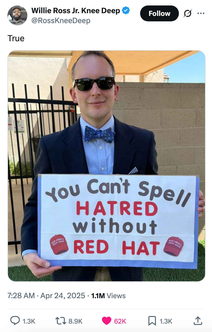 Person in a suit and bow tie holds sign reading, &quot;You Can't Spell HATRED without RED HAT,&quot; with images of red hats