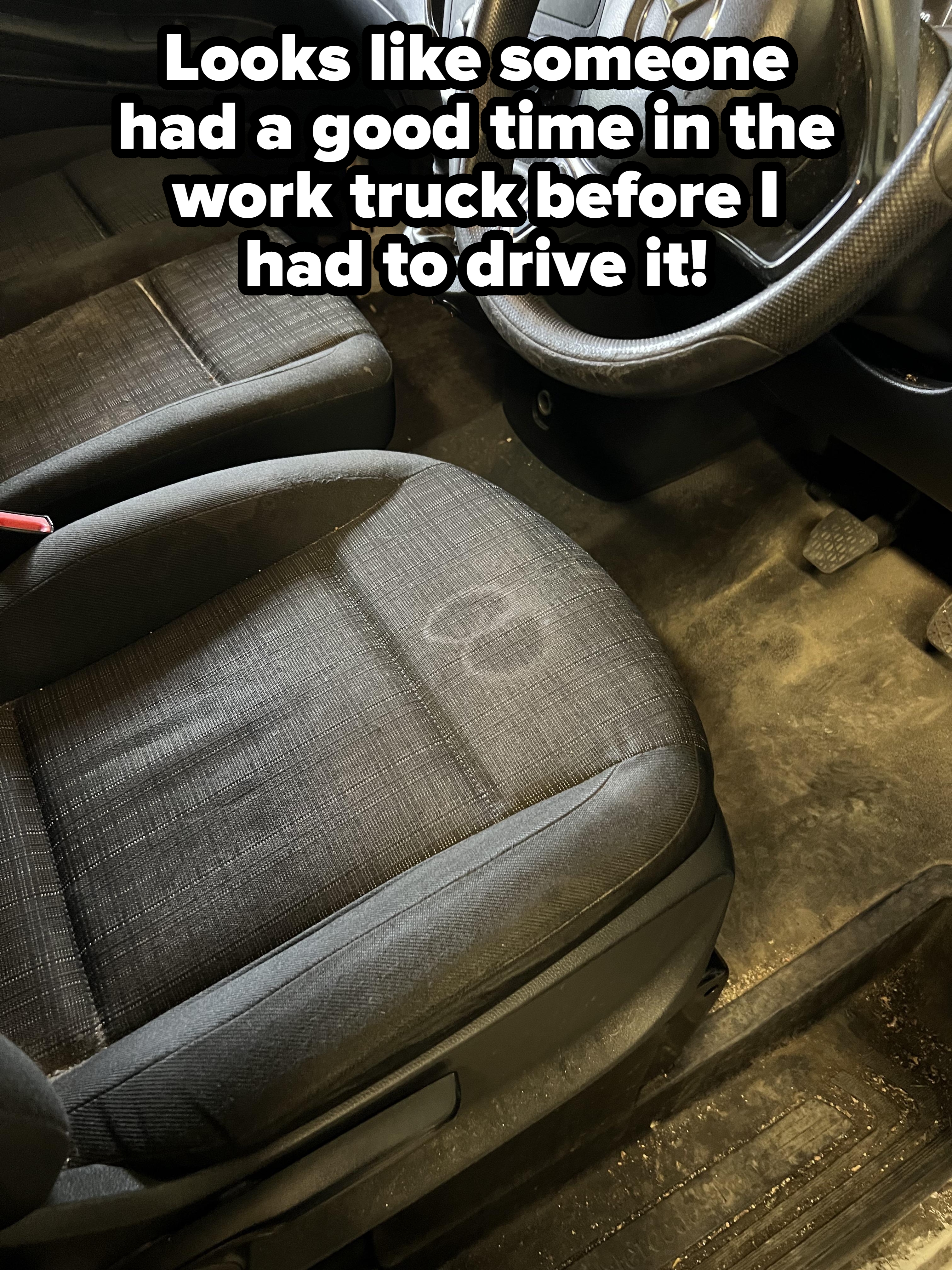Car interior showing wear on the driver's seat, steering wheel, and floor, highlighting signs of frequent use