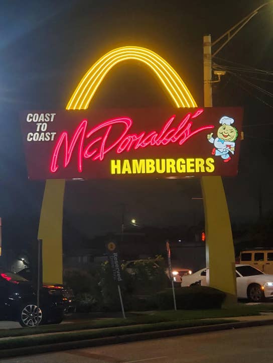 Retro McDonald's sign with one yellow arch and a cartoon chef