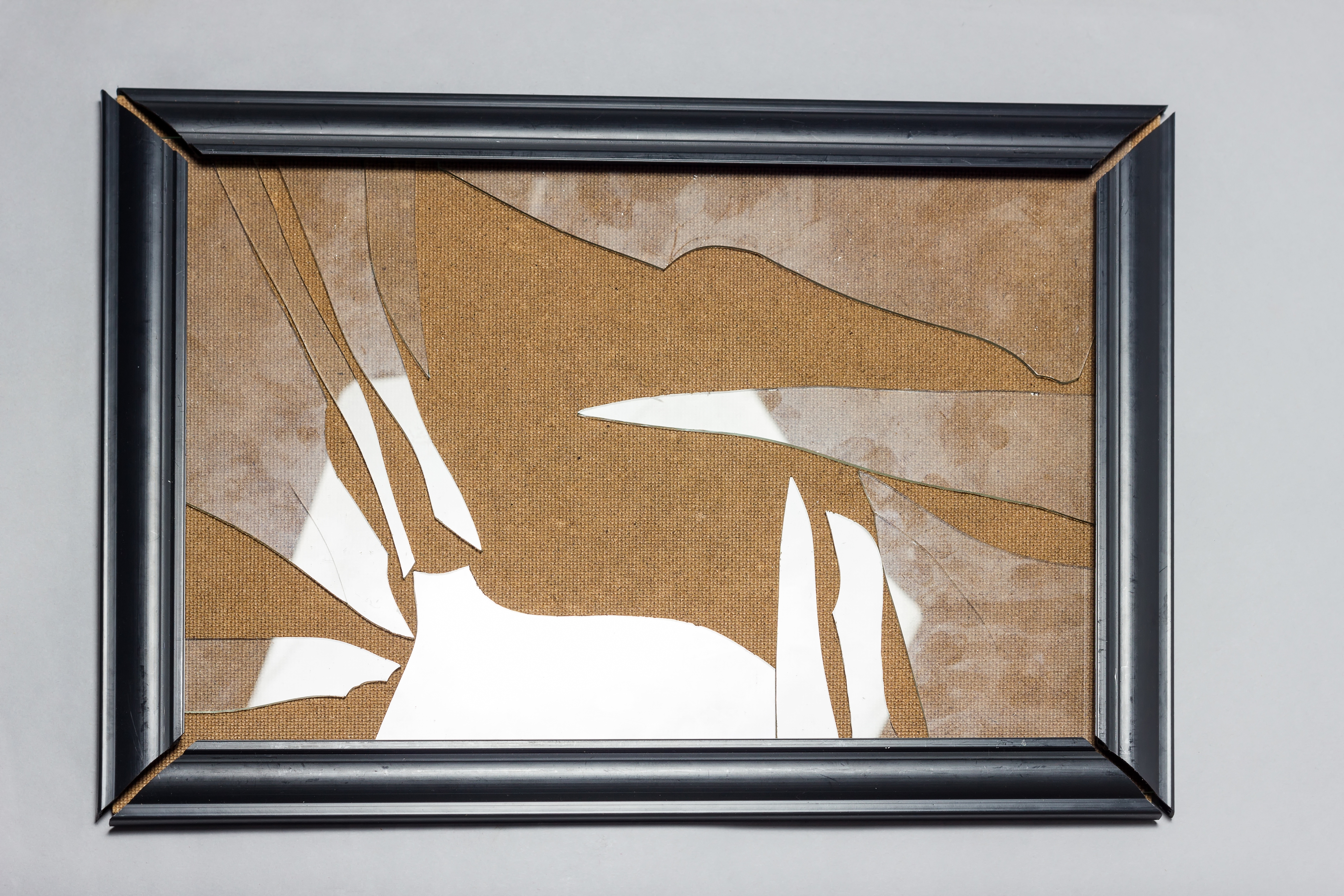 Framed artwork with broken glass and abstract shapes, suggesting themes of fragmentation and complexity