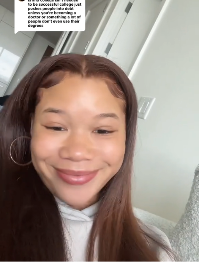 Person smiling indoors, responding to a comment about college and success