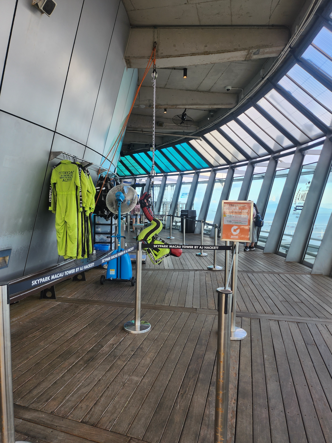Bungee jumping setup in a modern, indoor observation deck with safety gear and harnesses displayed, indicating adventure sports opportunity at a high location
